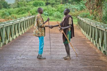 Two men shake hands on the bridge