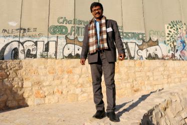 Dinesh Suna by the Separation Wall at Bethlehem on the West Bank. © Peter Kenny/WCC